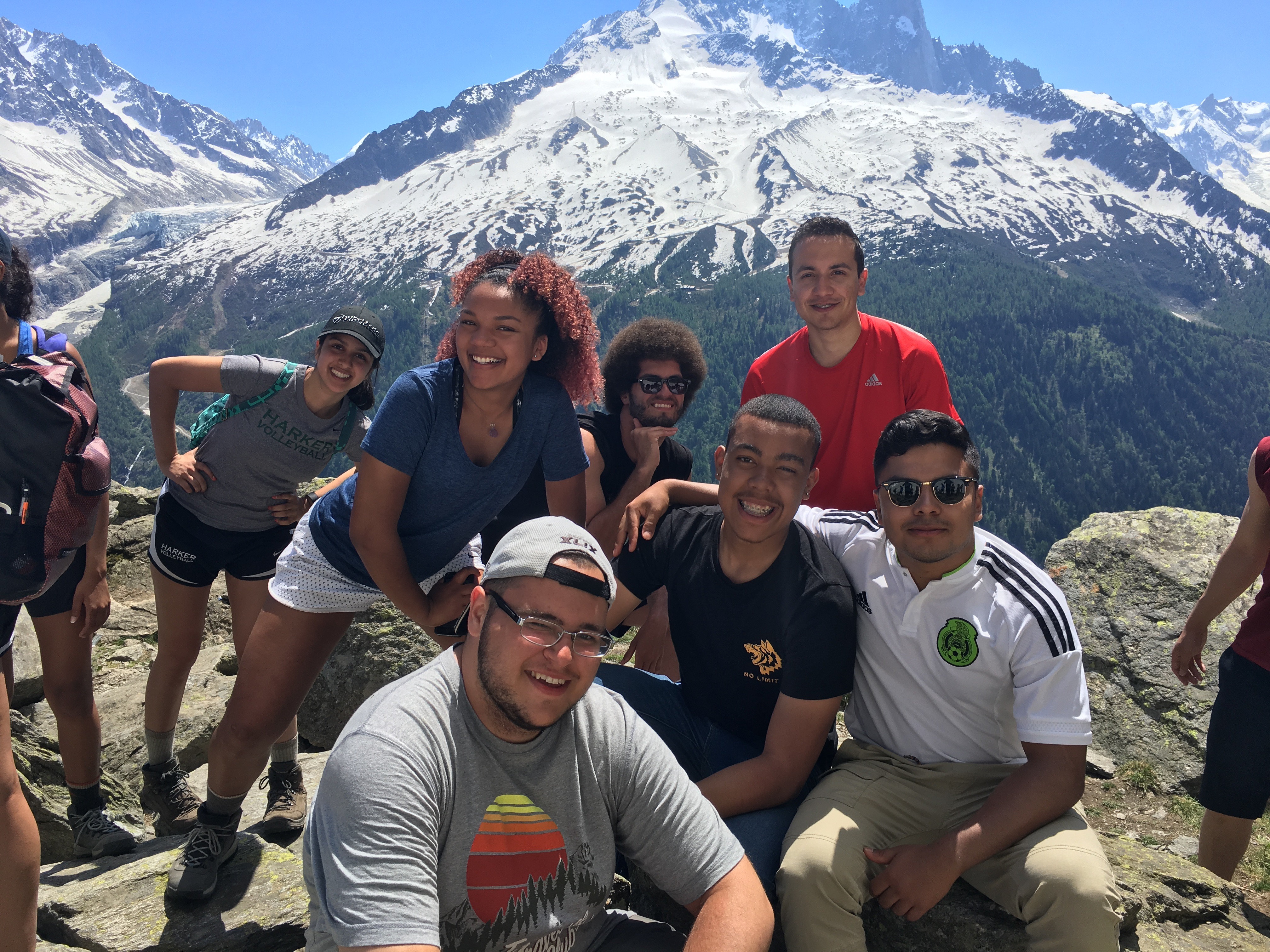 Against the backdrop of a snow-capped mountain, students face the camera and smile