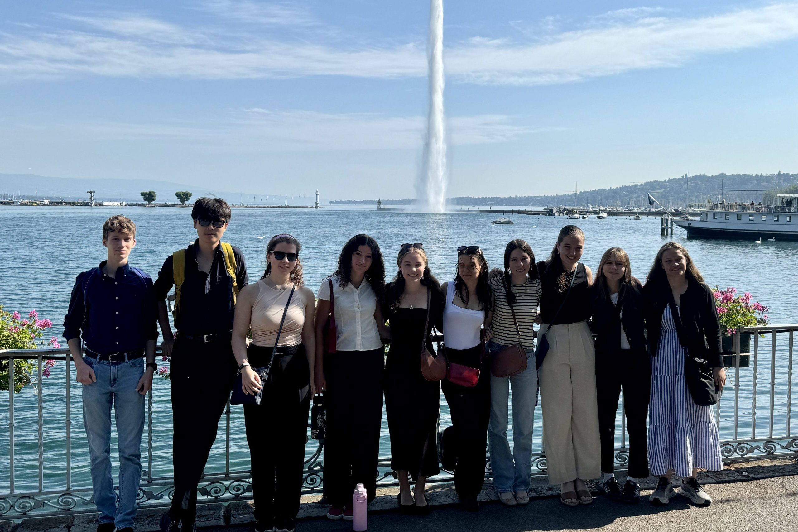 High school students on a program excursion to Geneva, they pose for a photo in front of the Jet d'Eau de Genève. This is for their international Relations course. 
