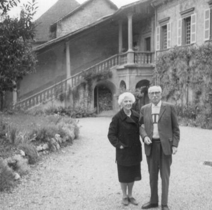 A black-and-white portrait of the MacJannets in front of the Priory.